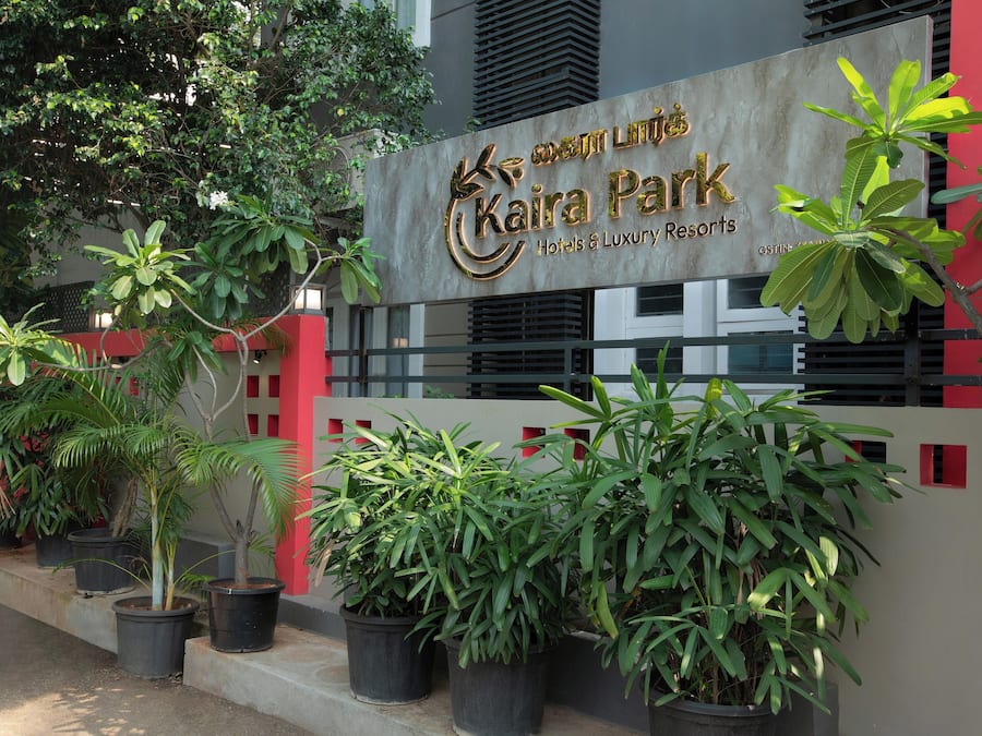 A sign for Kaira Park Hotels & Luxury Resorts with potted plants in front.