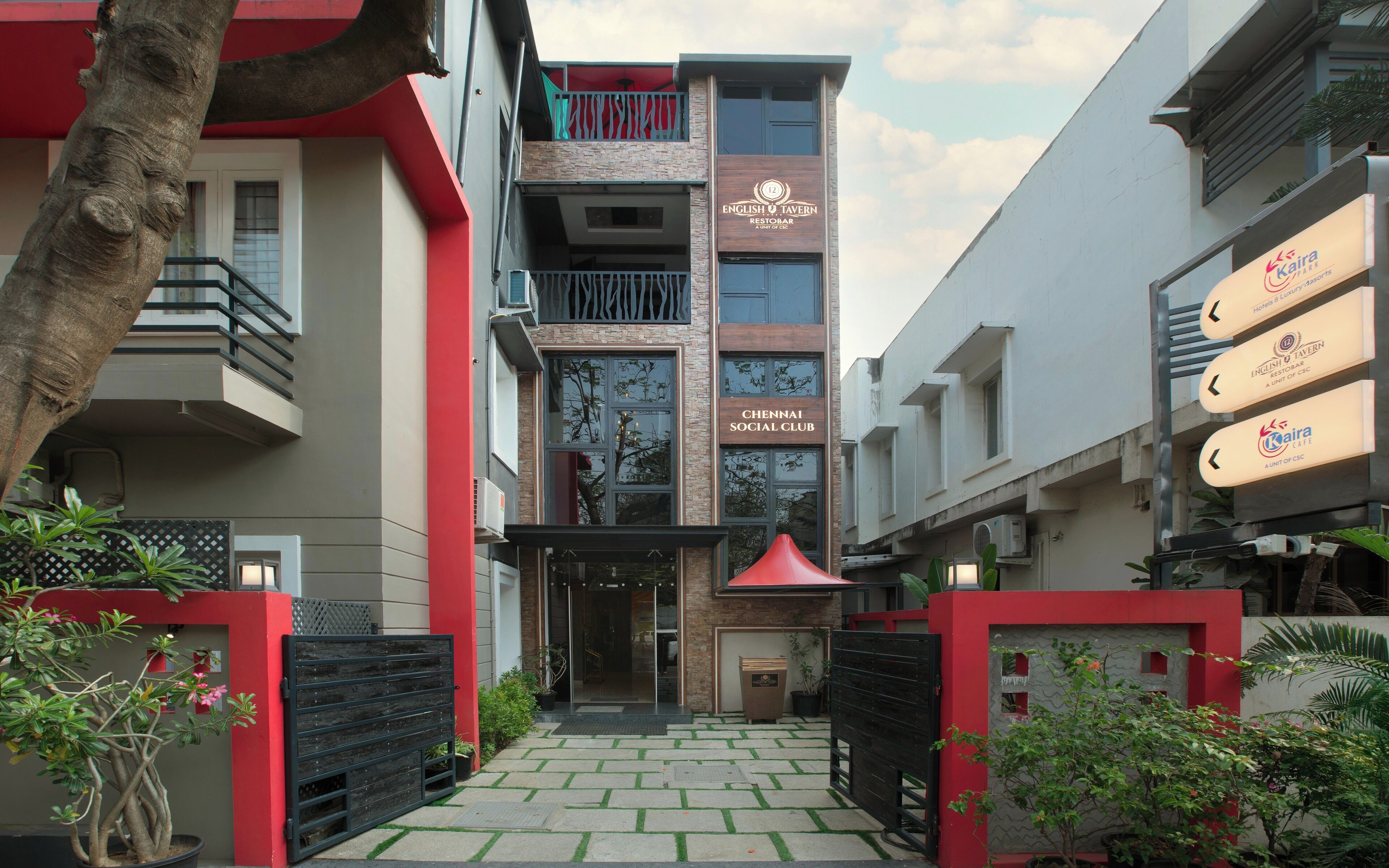 A modern building with a sign for 'English Tavern Restobar' and 'Chennai Social Club'.