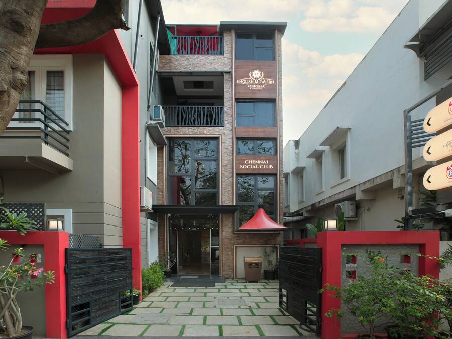 A modern building with a sign for 'English Tavern Restobar' and 'Chennai Social Club'.