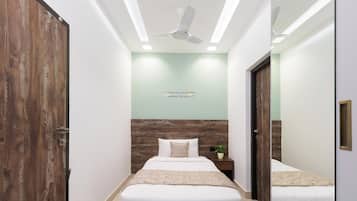 A modern bedroom with a large bed, a ceiling fan, and a motivational quote on the wall.