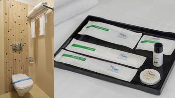 Ein Badezimmer mit Toilette, Handtuchhalter und einer Ablage mit Toilettenartikeln, darunter ein Kamm, eine Dentalset und Seife.