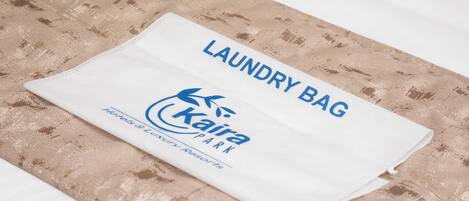 A neatly folded white laundry bag with the text "LAUNDRY BAG" and "Kaira Park" on it.
