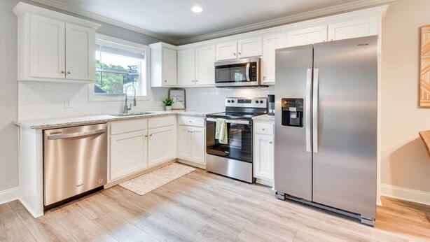 A modern kitchen with white cabinetry, stainless steel appliances, and a dishwasher. - Walk to Main St & River: Downtown Helen Condo (Helen)