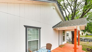 A covered outdoor seating area with a table and chairs, a wooden deck, and a white building with a window. - 1 Mi to Dtwn: Family Home w/ Porch in Brownwood (Brownwood)