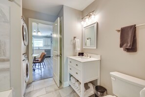 Un bagno moderno con un mobile lavabo bianco, uno specchio grande e un porta asciugamani.