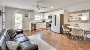 A modern kitchen with white cabinets, stainless steel appliances, and a dining area with a round table and chairs. - < 1 Mi to Tubing: Sleek Condo in Downtown Helen (Helen)