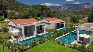 A resort with multiple swimming pools, stone walls, and red-tiled roofs. - Casa Dila (Marmaris)