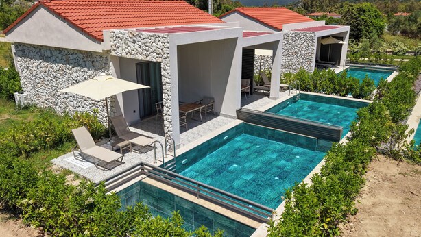 A modern villa with a swimming pool, stone walls, and outdoor seating. - Casa Dila (Marmaris)