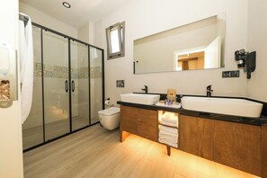 A modern bathroom with a glass shower enclosure, a double sink vanity, and a large mirror. - Casa Dila (Marmaris)