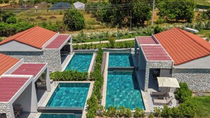 A pool area with two rectangular pools, stone walls, and red-tiled roofs. - Casa Dila (Marmaris)