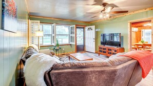 A cozy living room with a large sofa, a television, and a ceiling fan. - Deck, Hot Tub & Lake View: Brownwood Home! (Brownwood)