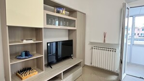 Moderni olohuone, jossa on sisäänrakennettu televisio, hyllyt ja patteri.