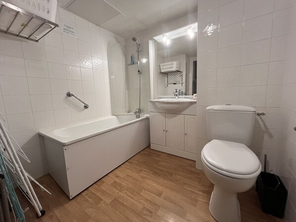 Une salle de bain avec une baignoire, des toilettes et un lavabo.