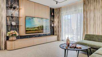 Villa – deluxe | Oppholdsområde | En 100-centimeters Flatskjerm-TV med kabel-kanaler