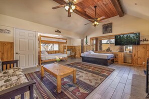 A cozy cabin-style room with a bunk bed, a sofa, a television, and a wooden ceiling. - Cabin Suite, 2 Bedroom (Big Bear Lake)