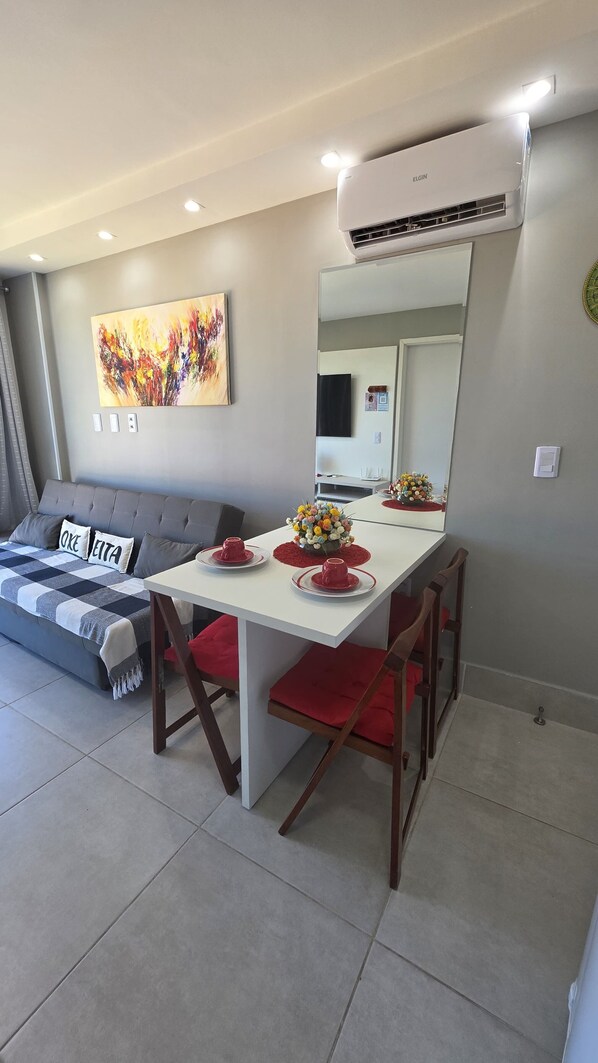 A modern living room with a dining table, sofa, and a large mirror. - Aline Duque 308 no Centro de Porto by LP (Ipojuca)