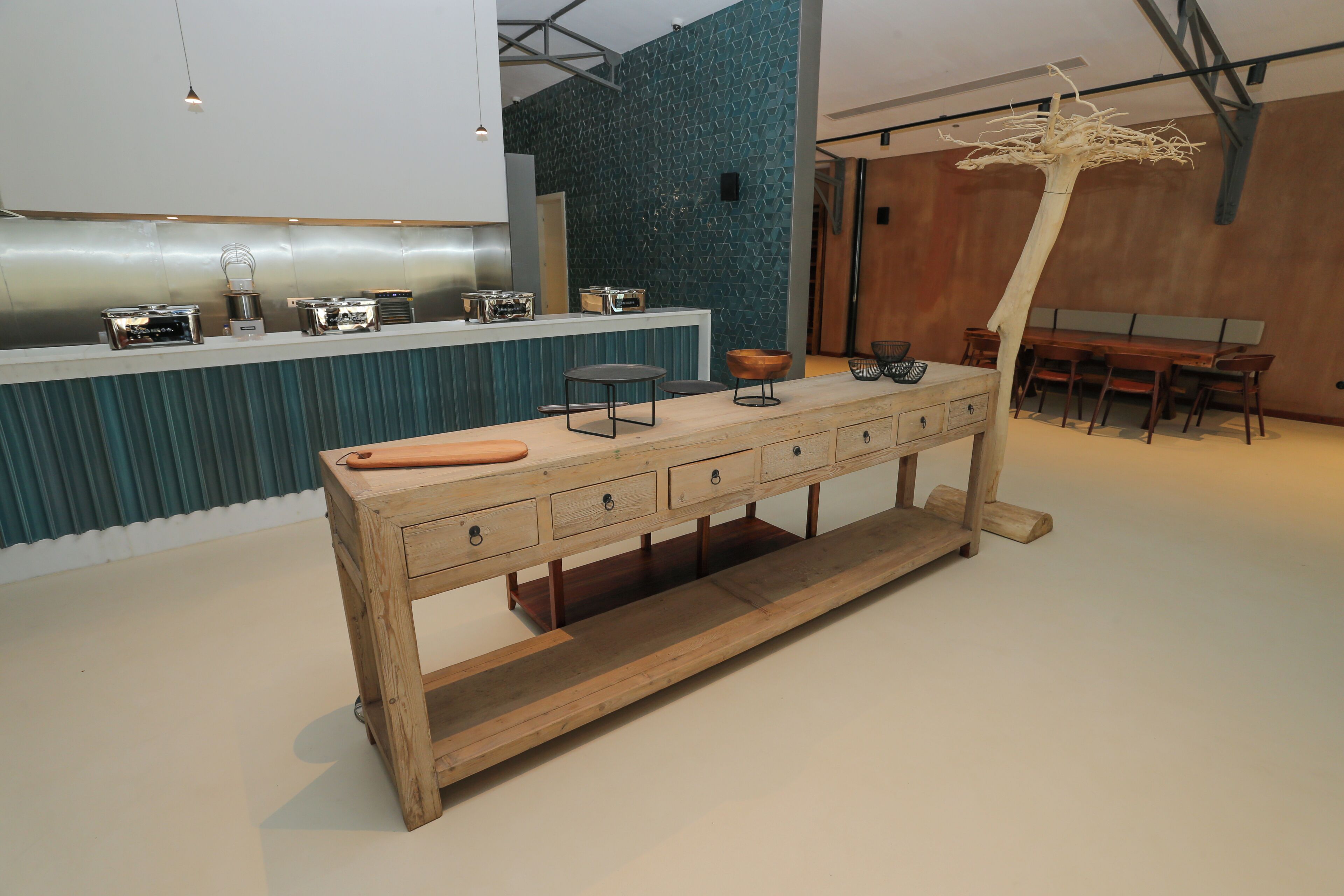 Une cuisine moderne dotée d’un îlot central en bois, d’appareils électroménagers en acier inoxydable et d’un décor mural original.