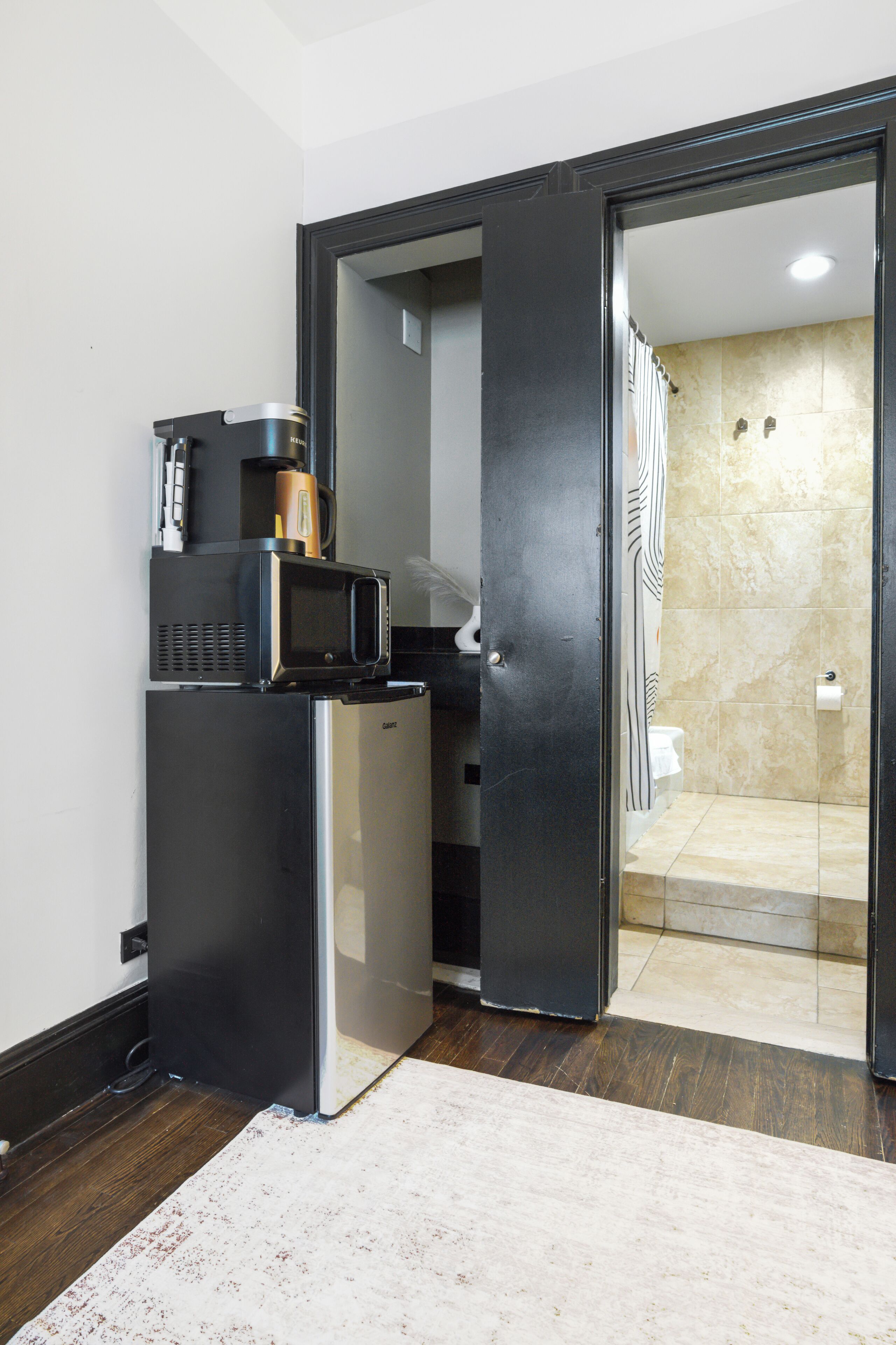 A compact kitchen with a refrigerator, microwave, and coffee maker.