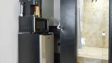 A compact kitchen with a refrigerator, microwave, and coffee maker.