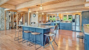 Une cuisine spacieuse dotée d’un grand îlot central, de tabourets de bar et d’appareils électroménagers modernes.