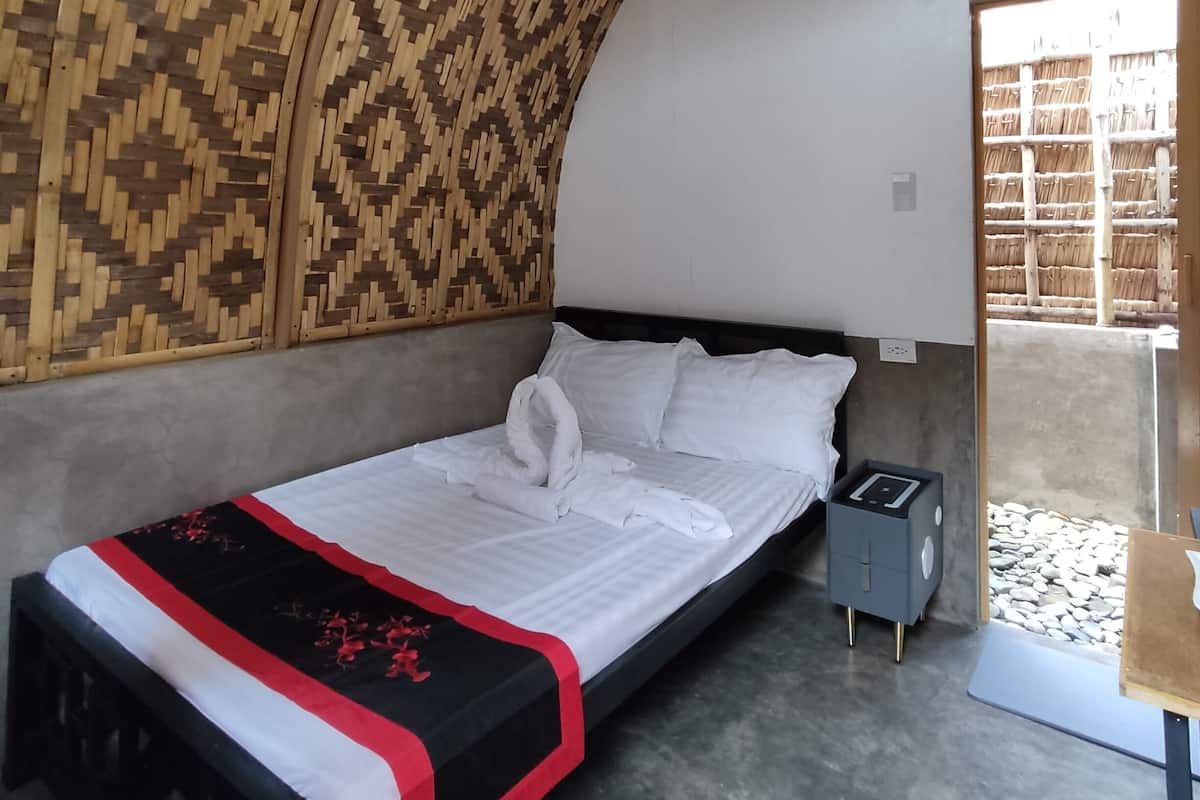 Una habitación con cama, mesita de noche y techo estampado.
