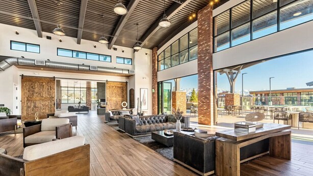 A spacious lobby with modern furniture, large windows, and a high ceiling.