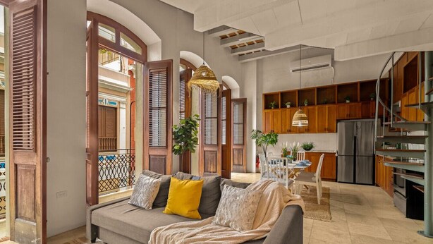 A spacious living area with a sofa, dining table, and kitchen.