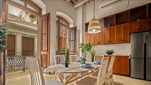 A spacious kitchen with wooden cabinets, a stainless steel refrigerator, and a dining area with a round table and chairs.