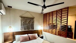 A modern hotel room with a large bed, a ceiling fan, a wooden partition, and a wall-mounted TV. - Loft in La Veleta w/ Pool,Balcony and rooftop! Near beach cenotes downtown (Q.R.)
