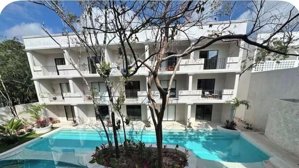 A multi-story building with a swimming pool surrounded by plants and trees. - Loft in La Veleta w/ Pool,Balcony and rooftop! Near beach cenotes downtown (Q.R.)