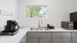 A kitchen with a coffee maker, a microwave, and a sink. - Austin Cozy Tiny Home | Fire Pit | Pet-Friendly (Austin)