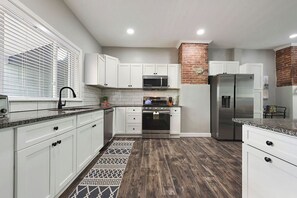 A modern kitchen with white cabinets, a stainless steel refrigerator, a microwave, and an oven. - REGAL BRICKS - Giant Outdoor Chess/Fire Pit/Game Room/Private Deck/Fire Pit (Pittsburgh)