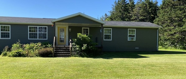 Stunning two-story home with a beautifully manicured lawn and a welcoming front door.