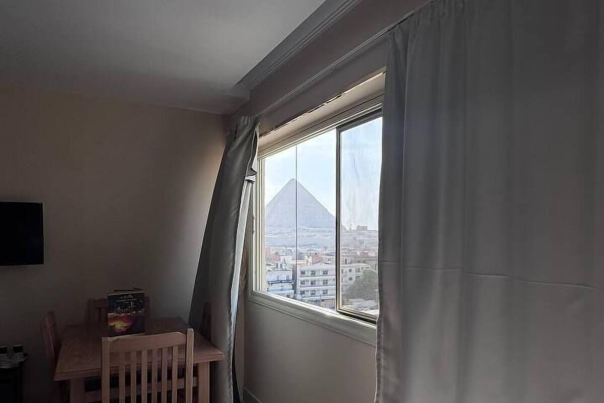 A hotel room with a bed, a desk, and a view of a mountain.