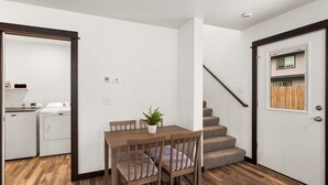 A compact living space with a dining area, a staircase, and a laundry room. - Fireside Retreat (Belgrade)
