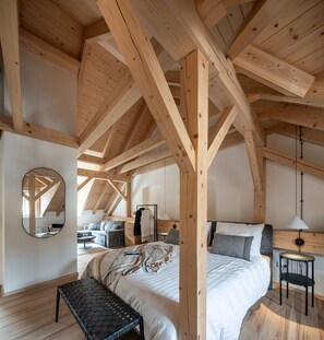 A spacious bedroom with a large bed, a bench, and a desk with a chair. - Graudenz - Cozy Apartments (Karlovy Vary)