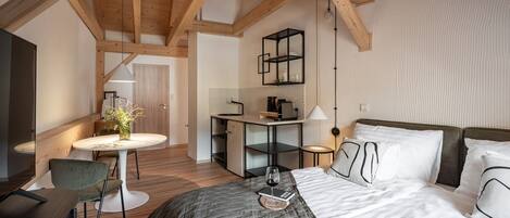 A modern bedroom with a large bed, a desk, and a chair.