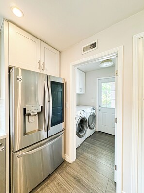Enjoy cooking in this well-equipped kitchen with a refrigerator, washer and dryer, and ample cabinetry.