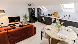 A modern apartment with a living room, dining area, kitchen, and a small balcony. - Stunning Sky view 2 BR Flat - Free WIFI, Parking (Harehills)