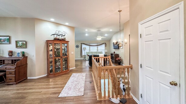 A spacious living room with hardwood floors, a wooden staircase, and a large white door. - Welcome to Your Home Away From Home (Florence)