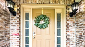A front door with a green wreath, a "NO SOLICITING" sign, and two wall-mounted lanterns. - Welcome to Your Home Away From Home (Florence)