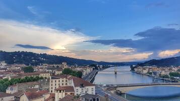 A river with a bridge, buildings, and hills in the background.