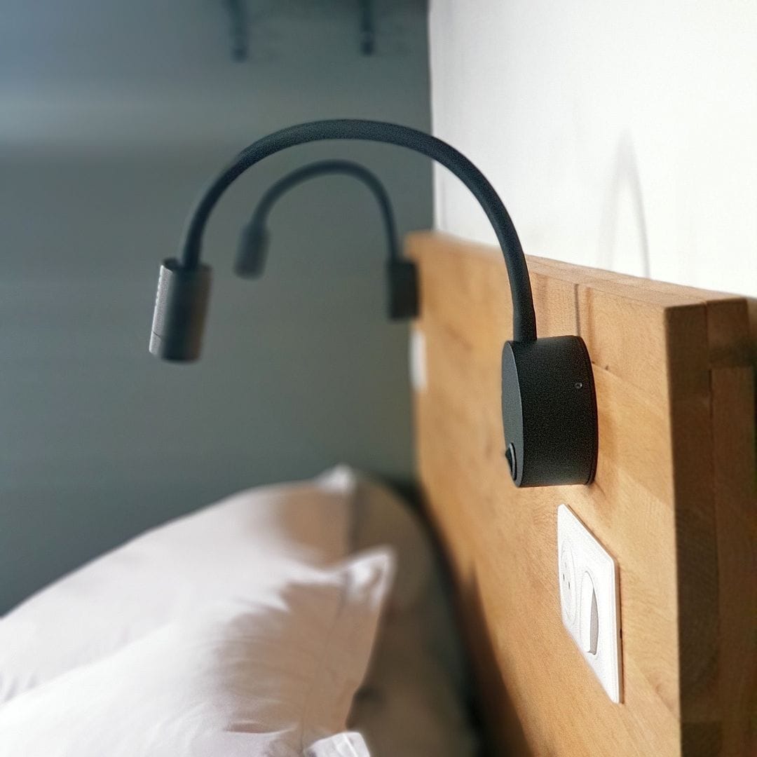A wooden headboard with a black headrest and a switch on the side.
