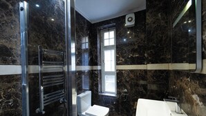 Ein modernes Badezimmer mit Duschkabine aus Glas, Toilette und Waschbecken.