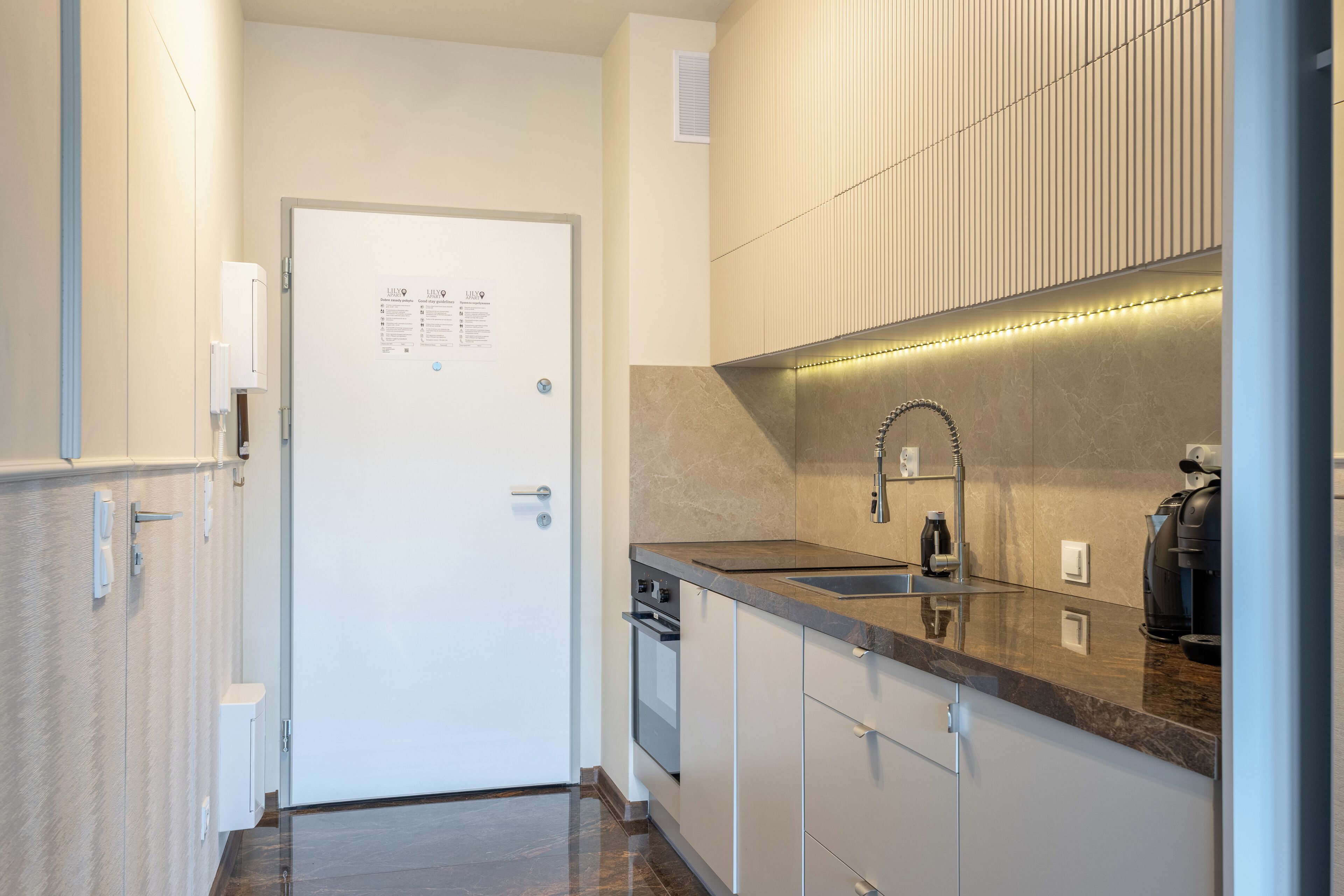 A modern kitchen with a sink, countertop, and cabinets.