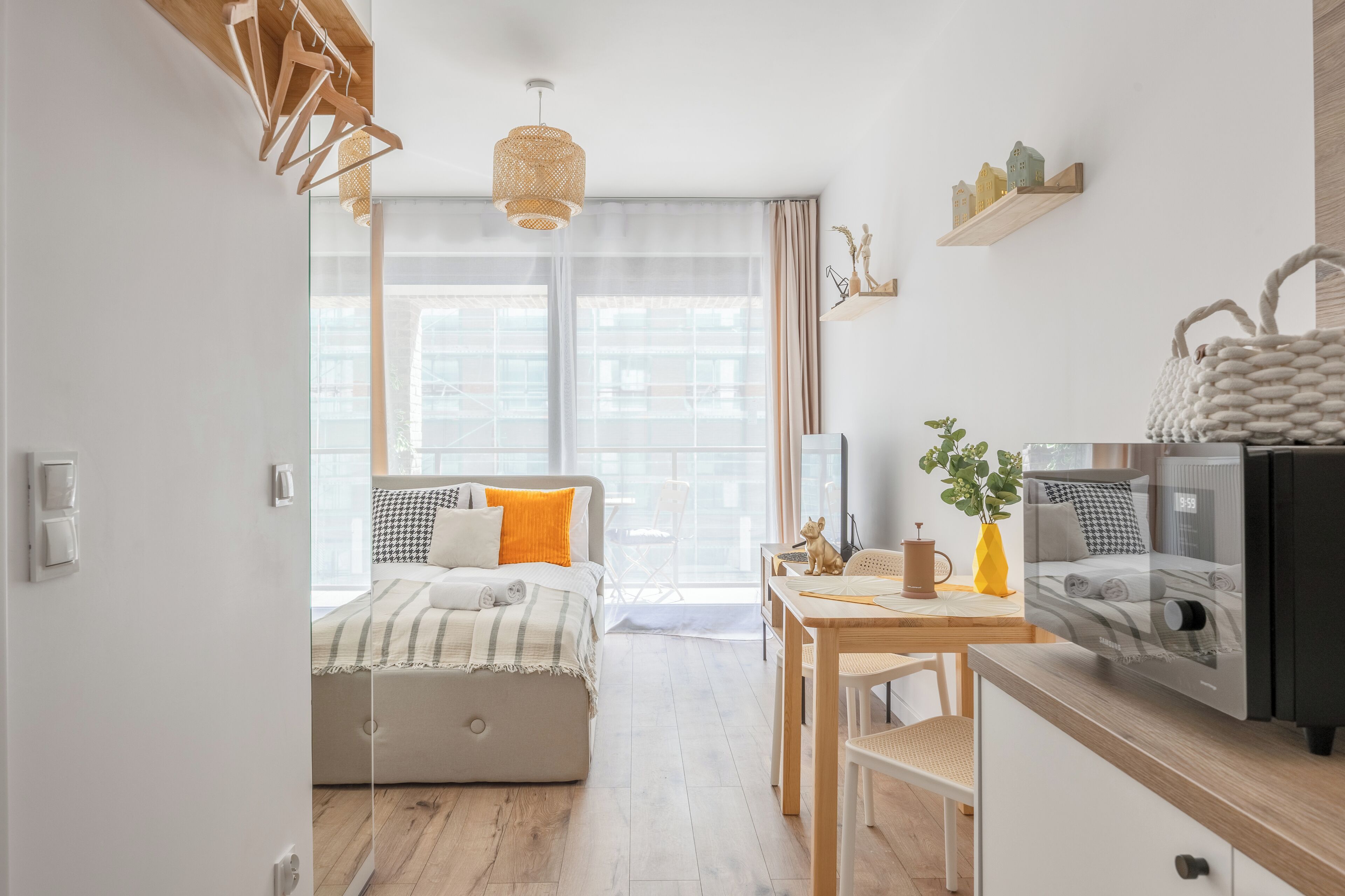 A modern bedroom with a bed, bedside table, and a view of the city.