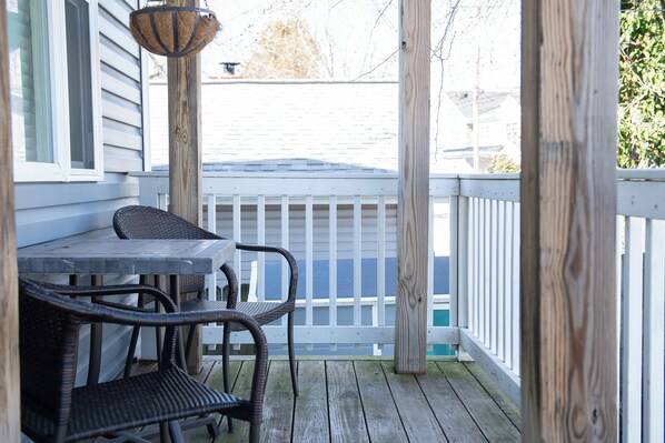 Enjoy a serene view of the water from this deck with a table and two chairs.