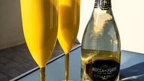 Two yellow wine glasses and a bottle of Rocca dei Forti wine on a table with a clear view of the sky. - B&B La Fenice Rome - Fiumicino. Close to the center of Rome and the airport. (Lazio)