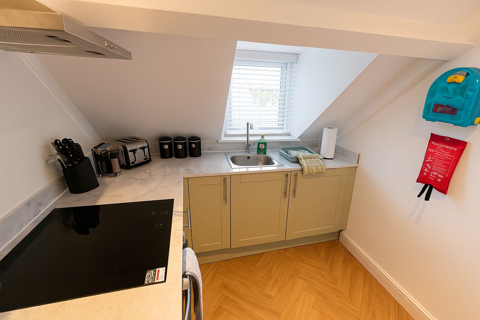 A compact kitchen with a window, a toaster, a sink, and a small countertop.
