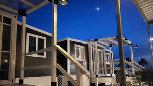 Un edificio con varias habitaciones, cada una con ventana y puerta. Se observan escaleras que dan acceso a las habitaciones.
